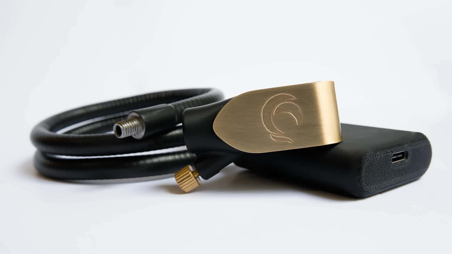 Zephyr mouthpiece resting on its base next to the coiled gooseneck, with the USB-C port visible