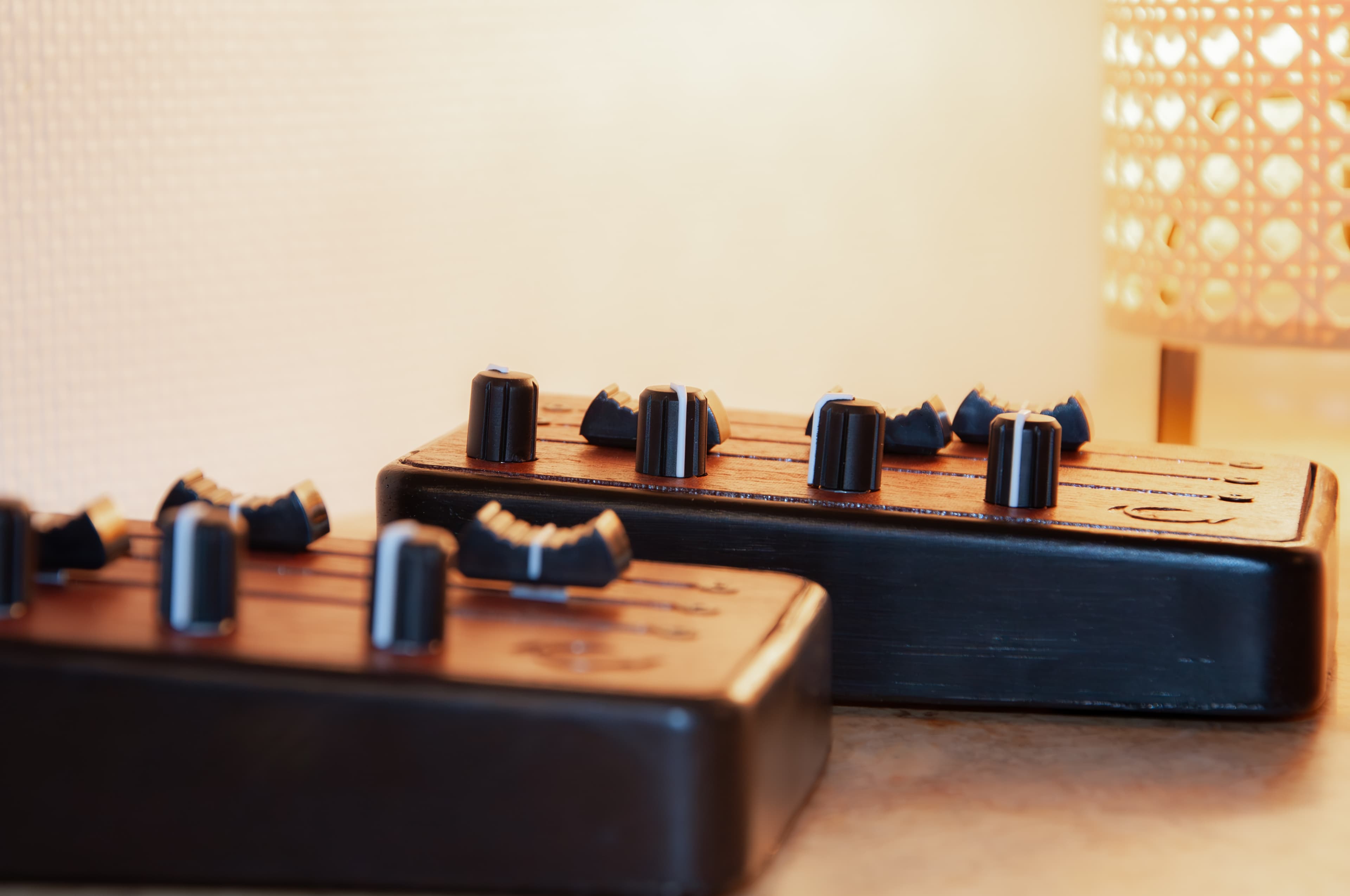 Two Brise MIDI Controllers on a table, with a soft amber light