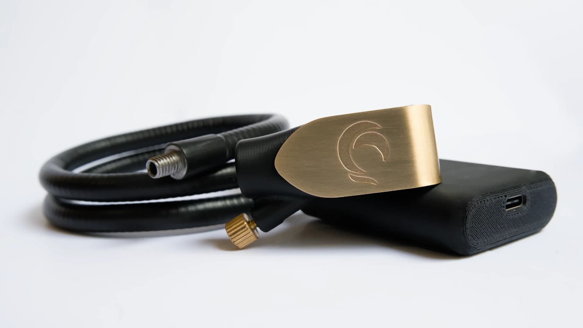 Zephyr mouthpiece resting on its base next to the coiled gooseneck, with the USB-C port visible